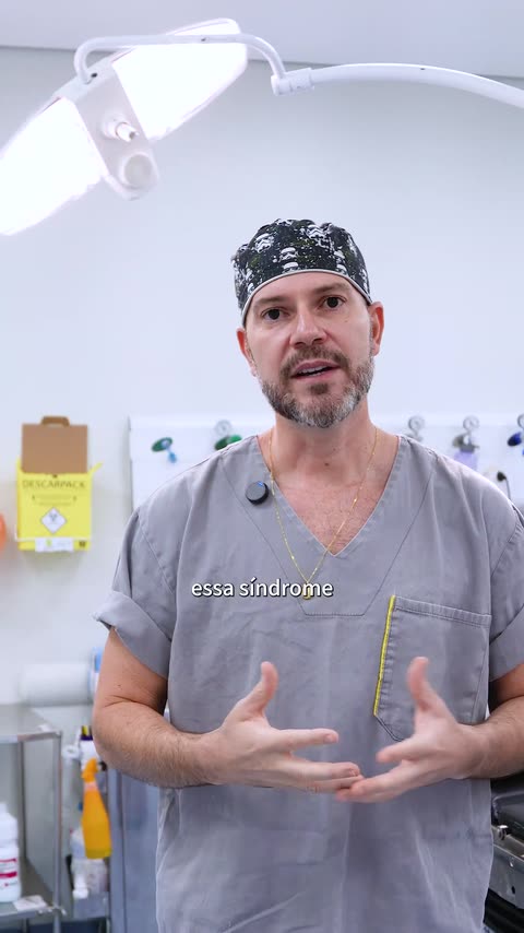 Neurocirurgião paramentado gravando conteúdo dentro do centro cirúrgico